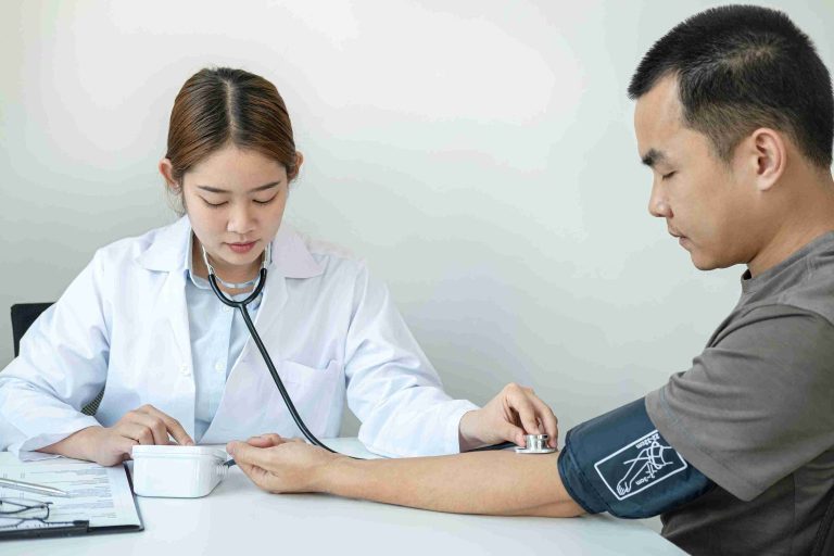 female doctor checking the blood pressure of male patient