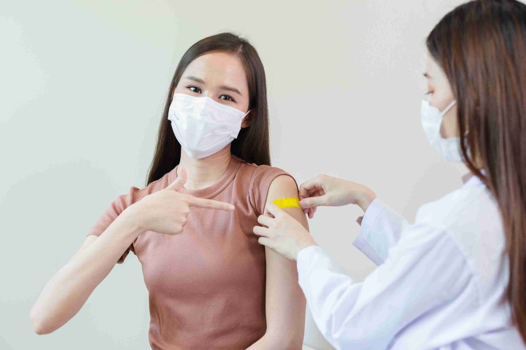 female patient pointing at her vaccinated arm