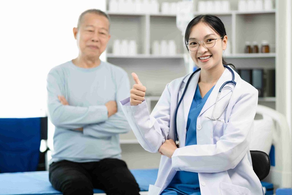young female doctor giving the thumbs up with an elderly patient