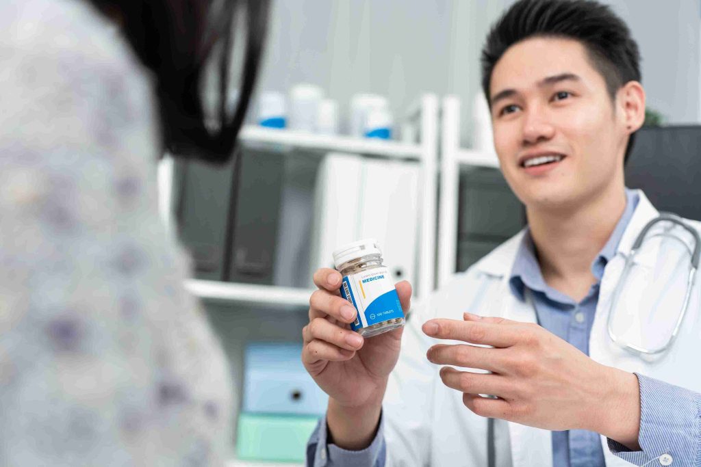 young doctor showing patient a medication