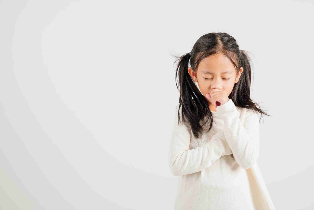 young girl with her hand on her mouth