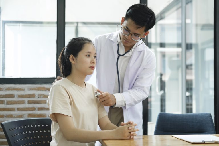 young male doctor examining a female patient