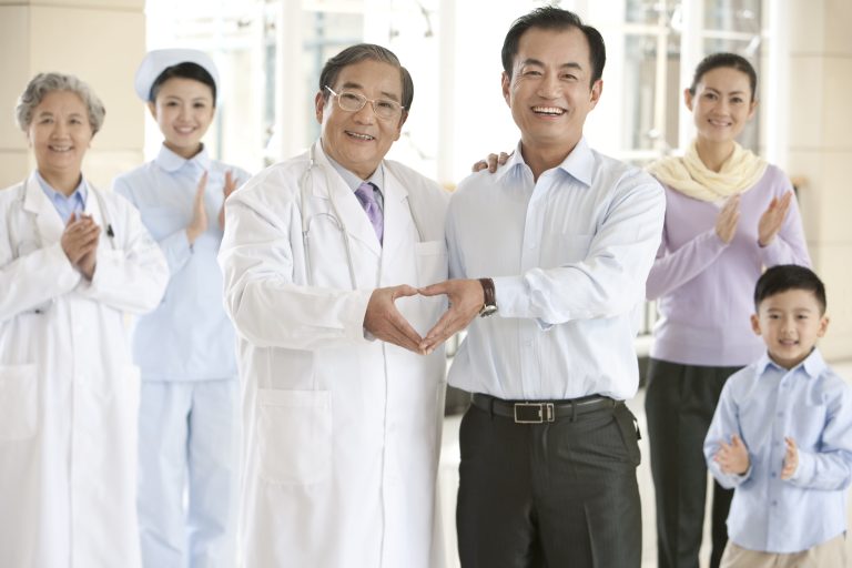 father making a heart shape with doctor