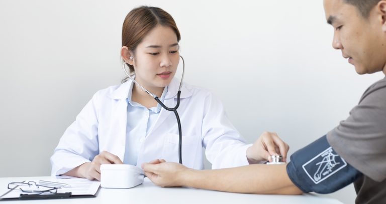 female doctor checking the bp of a male patient