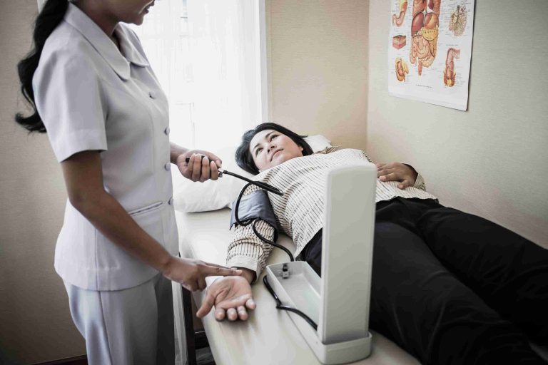nurse getting the blood pressure of a patient in bed