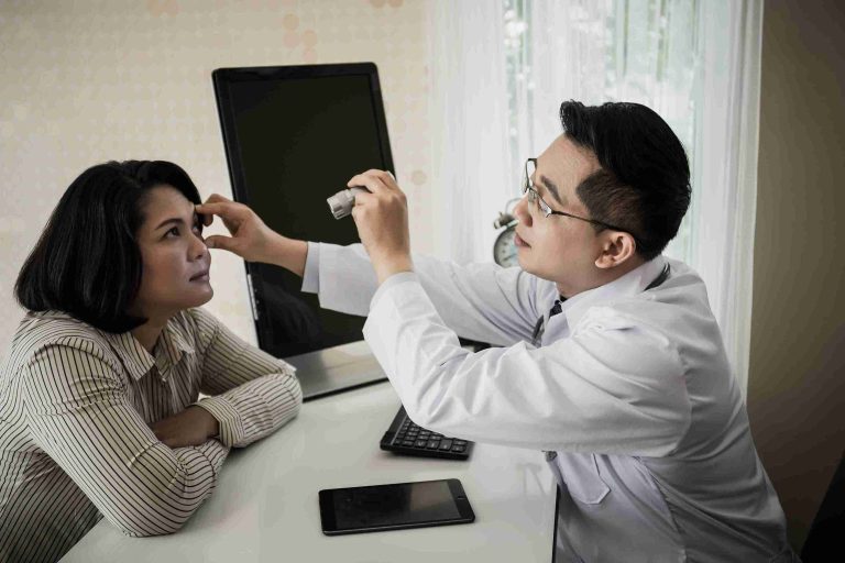 doctor examining the eye of a female patient