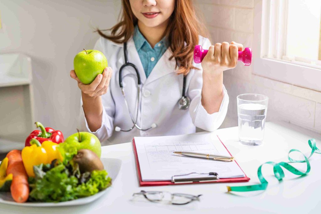 healthcare worker posing with fruits