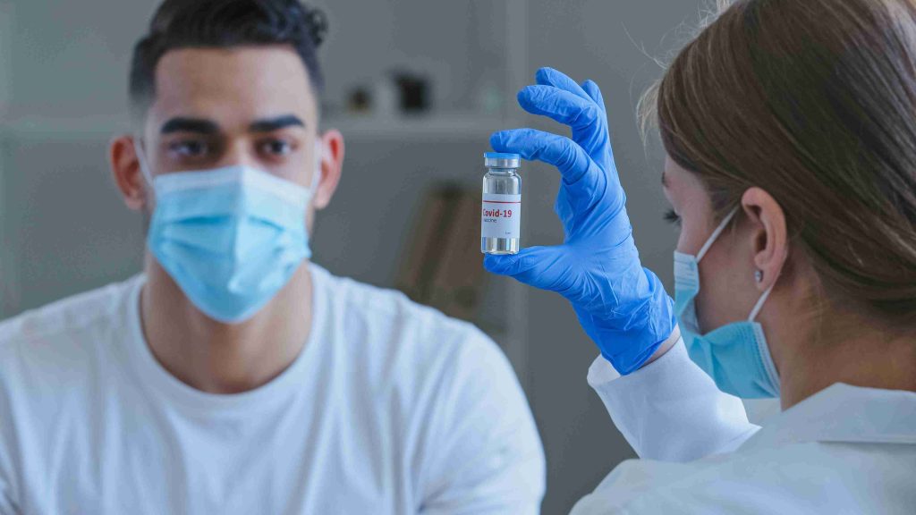 patient looking at a COVID 19 vaccine vial