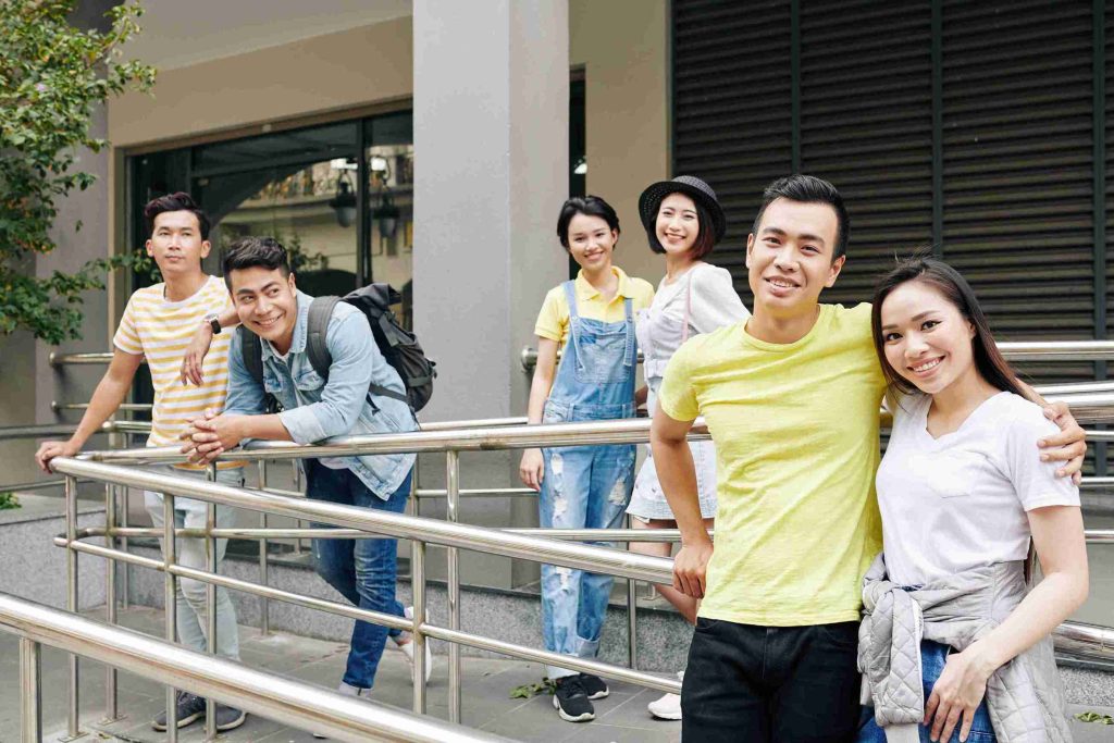 young people standing outdoors smiling happily