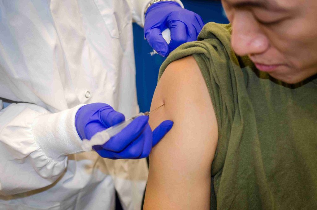 asian man getting the flu vaccine