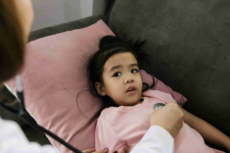 asian child with fever examined by a doctor