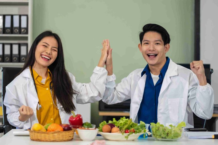 male and female doctors sitting infont of fruits and vegetables