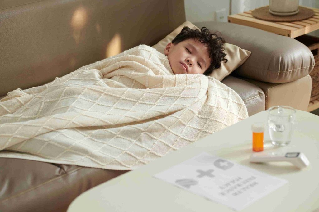 little boy with fever sleeping on the couch
