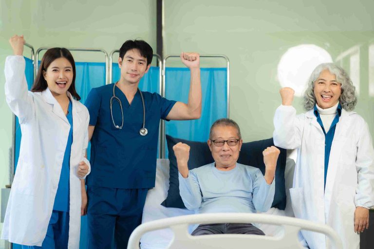 patient sitting in a hospital bed raising his fist