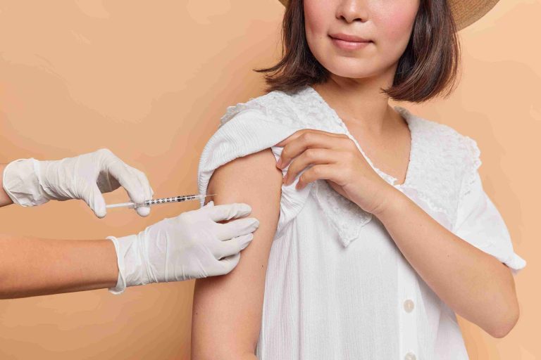 Healthcare worker giving a woman her flu shot.