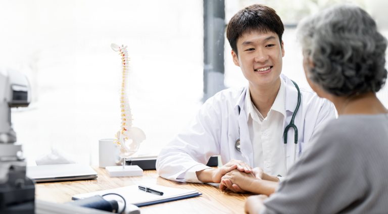 Young doctor speaking with an elderly patient.