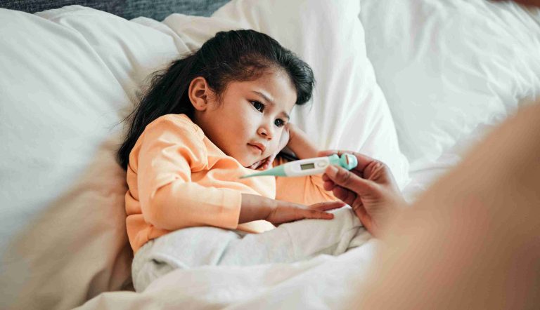 Mother checking a child's fever using a thermometer.
