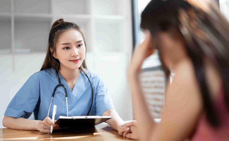 Female doctor smiling at a worried patient.