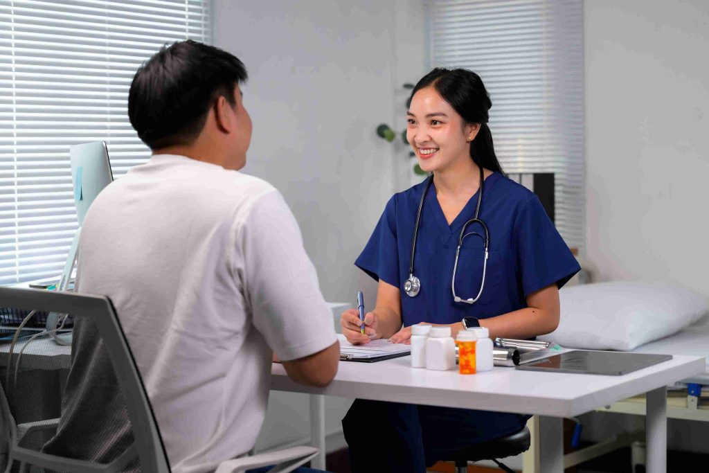 Doctor smiling at a male patient sat accross her.