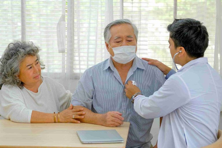 Elderly couple getting checked by a young doctor.