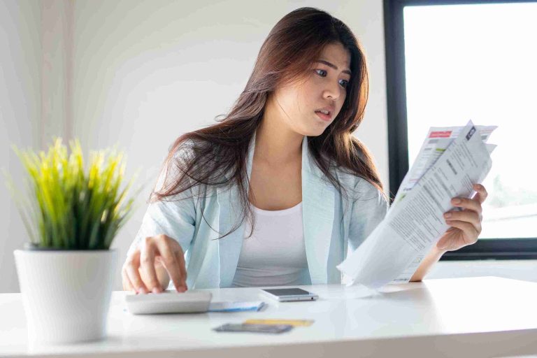 Woman looking worried while holding her medical bills.