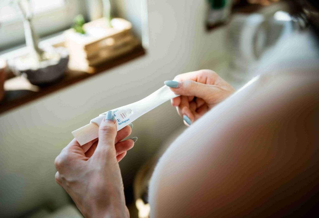 Woman holding a positive pregnancy test.