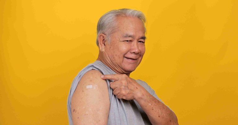 Elderly Asian showing off his flu vaccination.