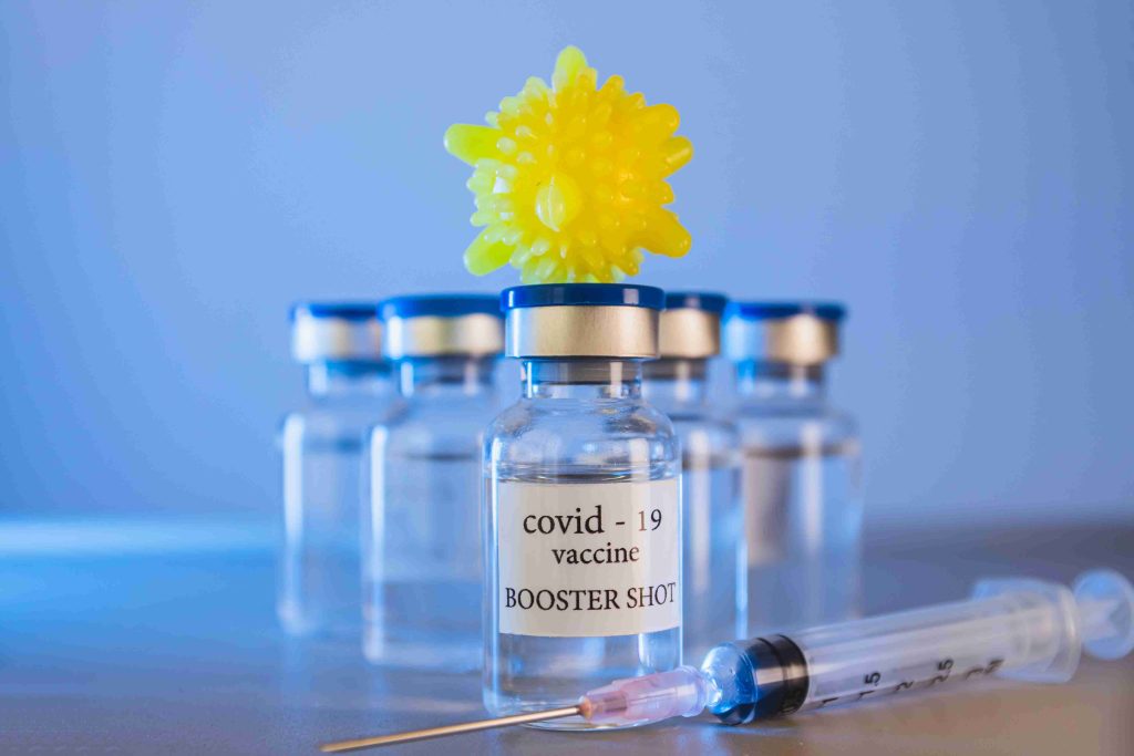 Image of COVID-19 booster shot vials and a syringe.