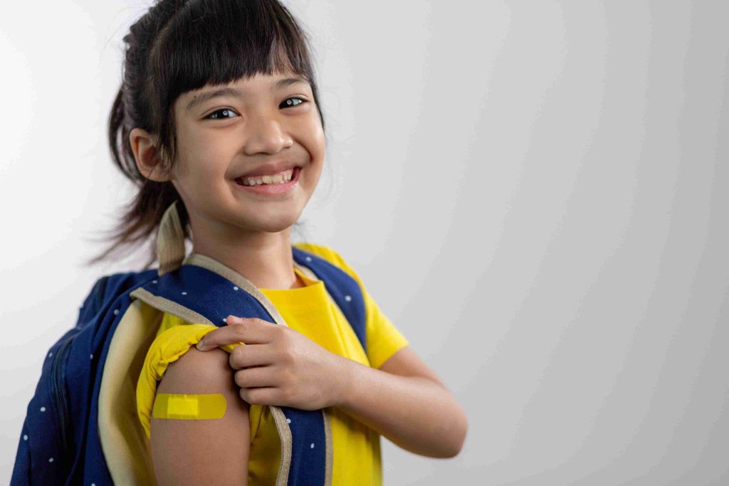 Young girl showing off her vaccinated arm.