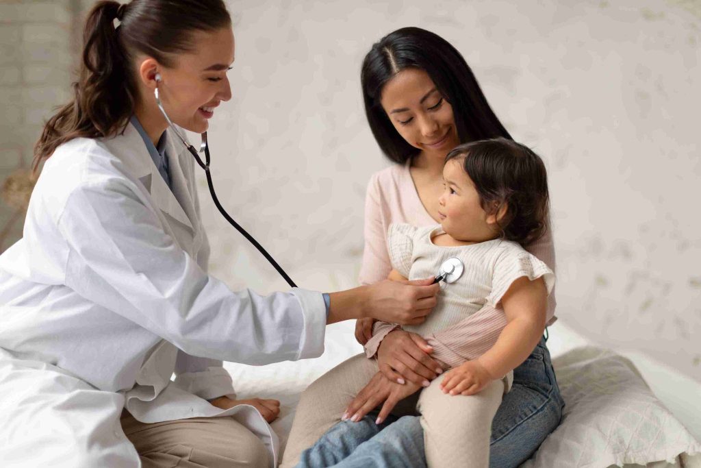 Female doctor checking heart rate of a toddler.