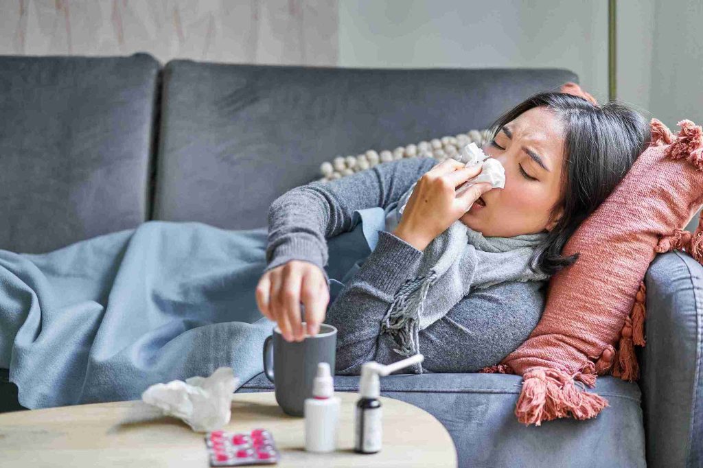 Woman with flu lying in her couch.