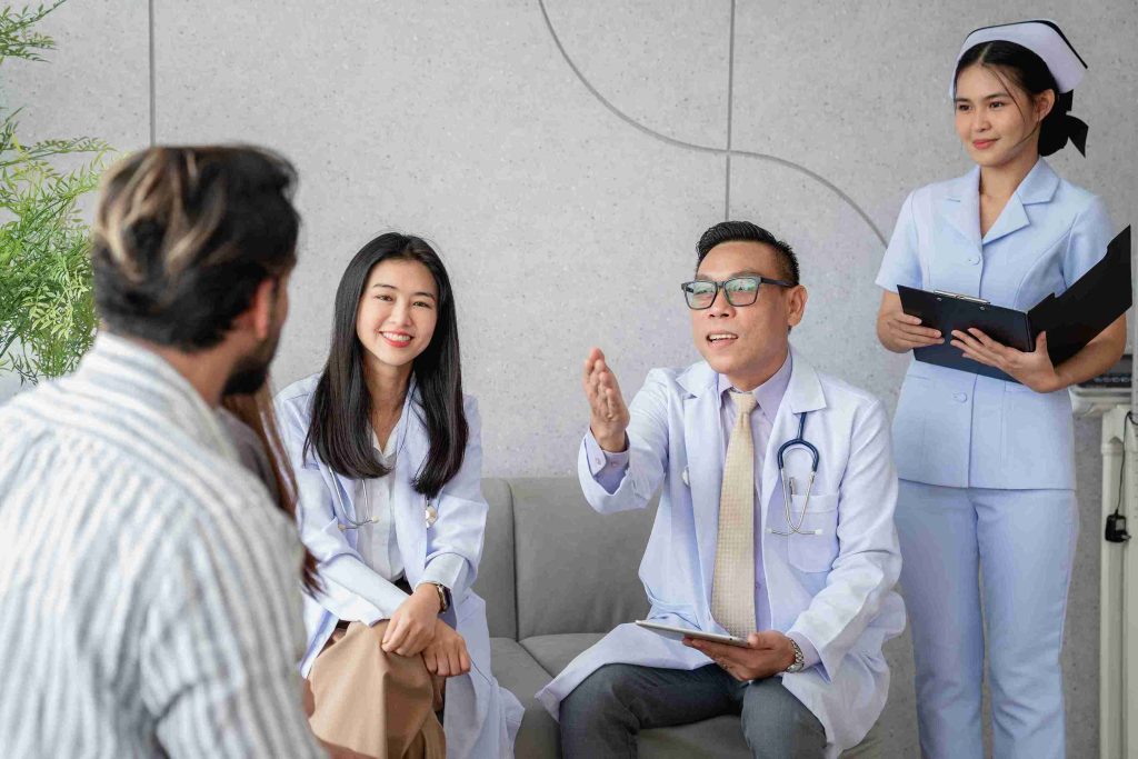 Healthcare workers speaking with a patient in the clinic.