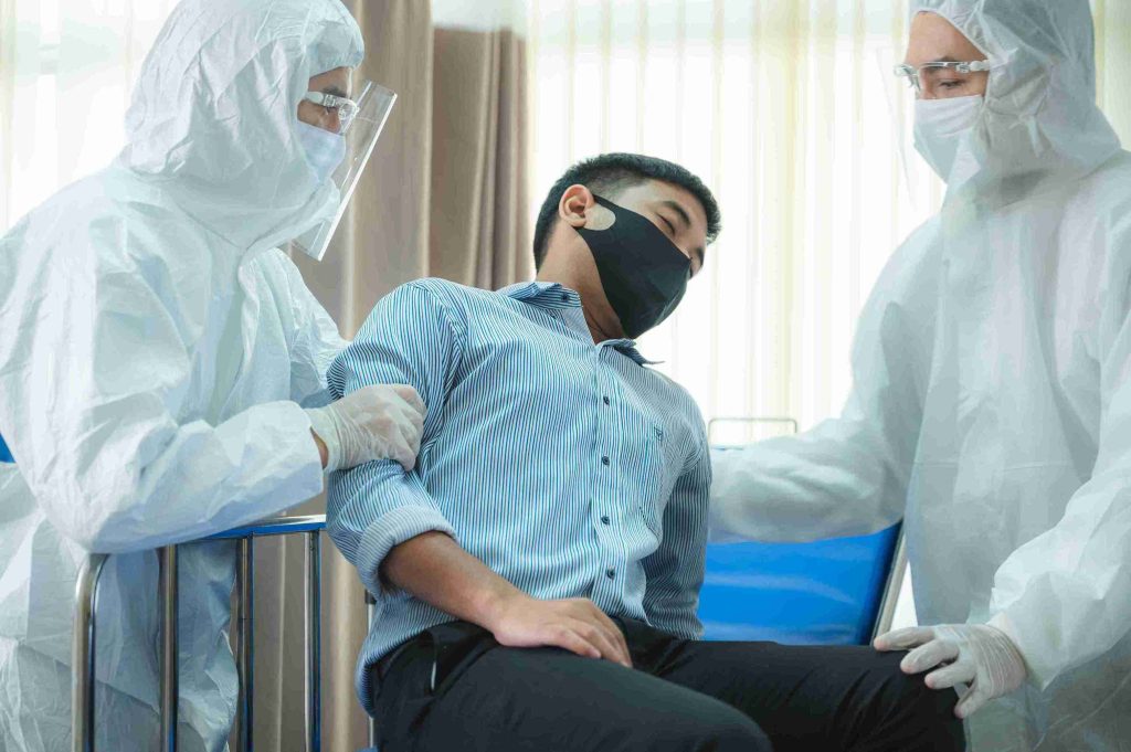 Patient with COVID being helped by healthcare professionals.