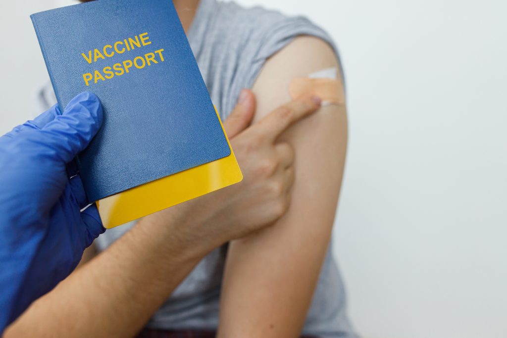 Image of a person pointing to her vaccination as showing a vaccine passport.