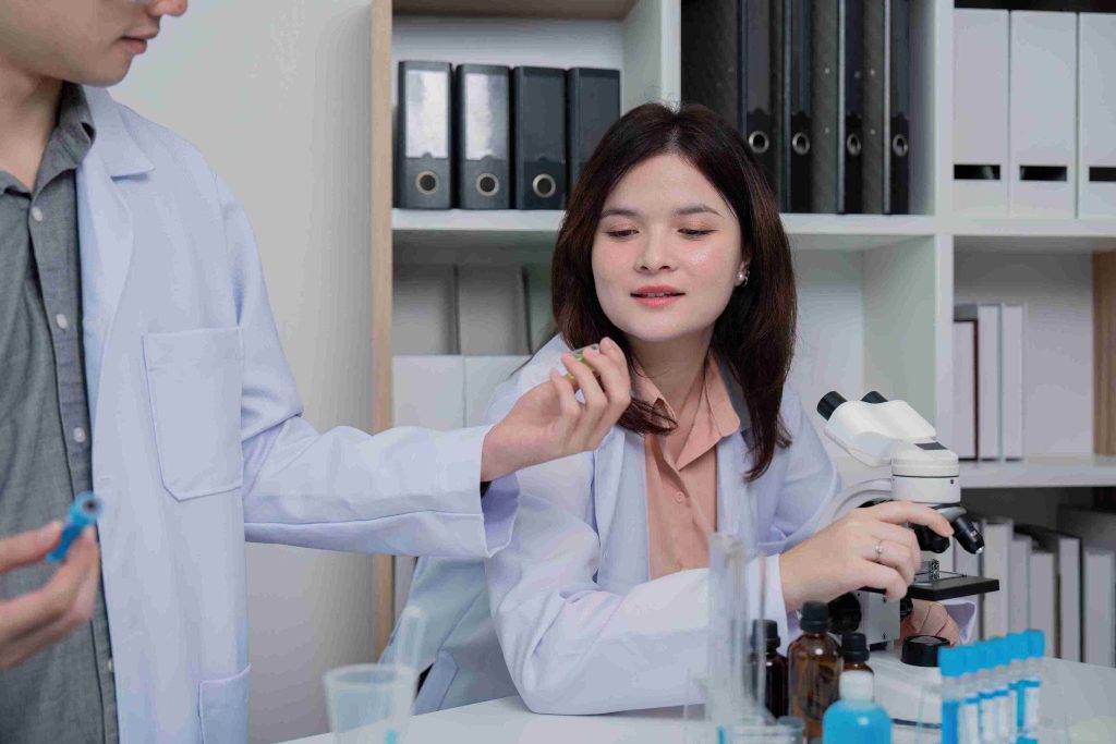 Healthcare workers working with microscopes and test tubes.