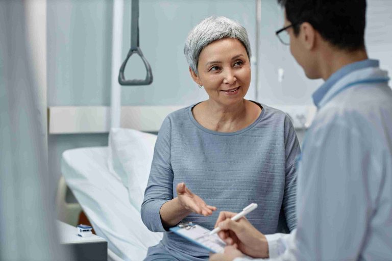 Elderly woman speaking with her doctor in a hospital.