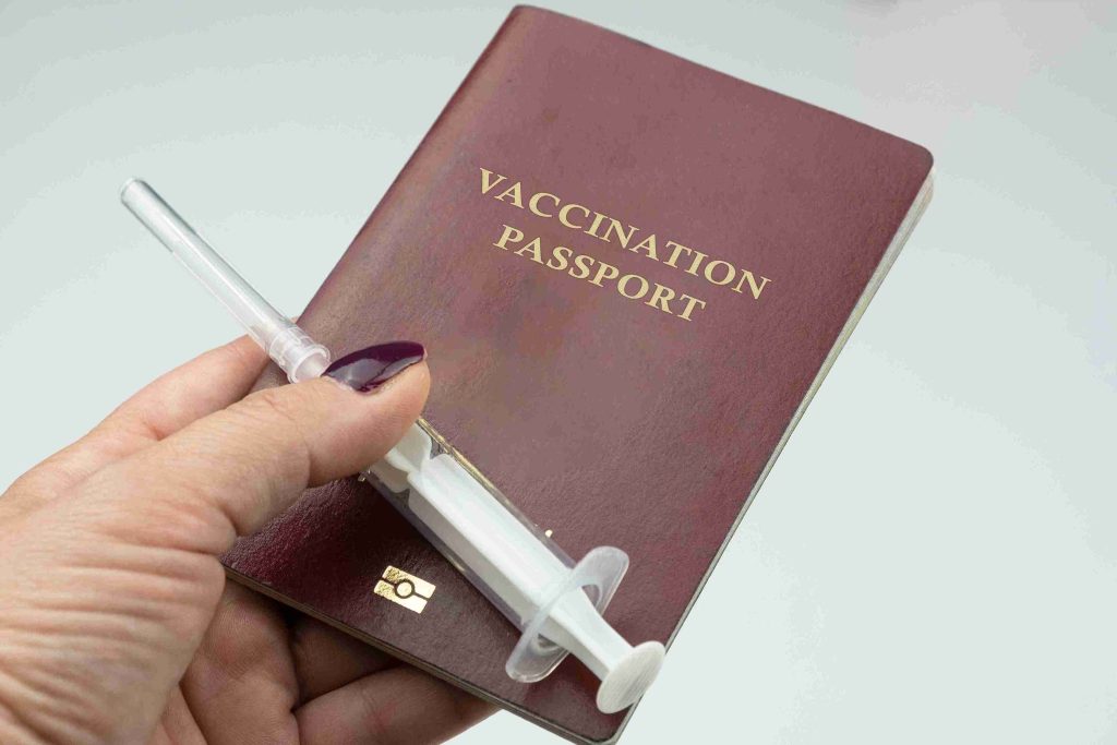 An image of a travel vaccination passport and injection.
