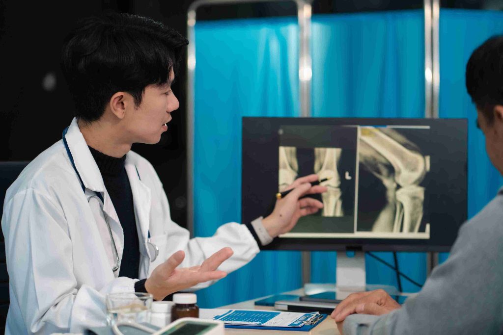 Medical doctor explaining X-ray results to a patient.