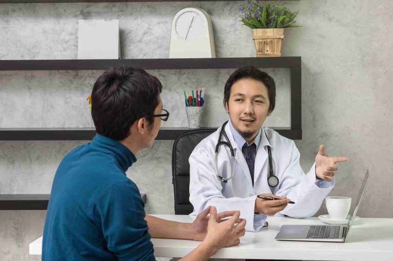 Medical professional speaking with a male patient.