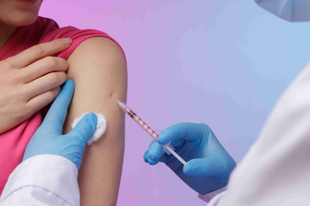 Healthcare worker giving a patient a flu vaccine on the arm.
