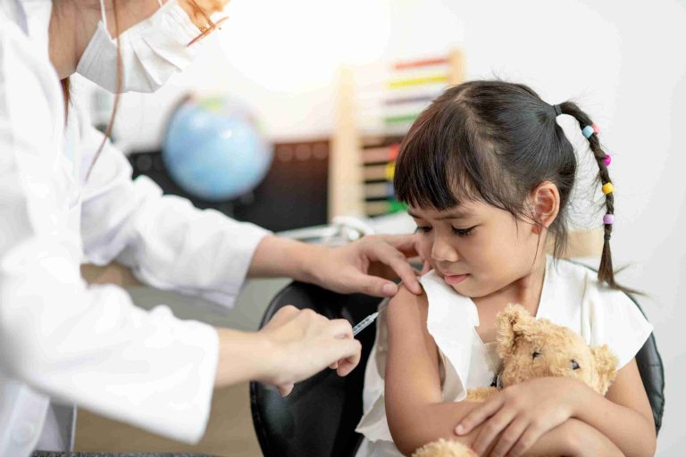 A young girl getting vaccinated by a healthcare worker.