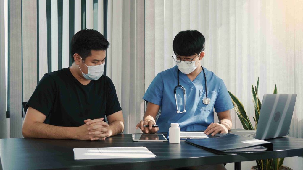 Doctor speaking with a migrant worker in Singapore.