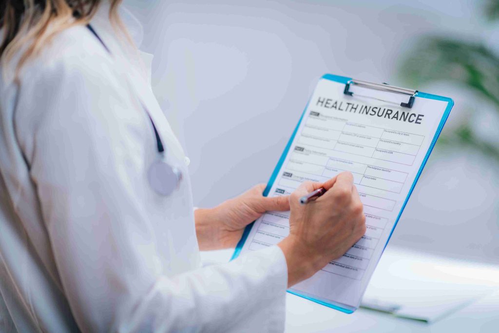 Healthcare worker filling out a medical insurance form.