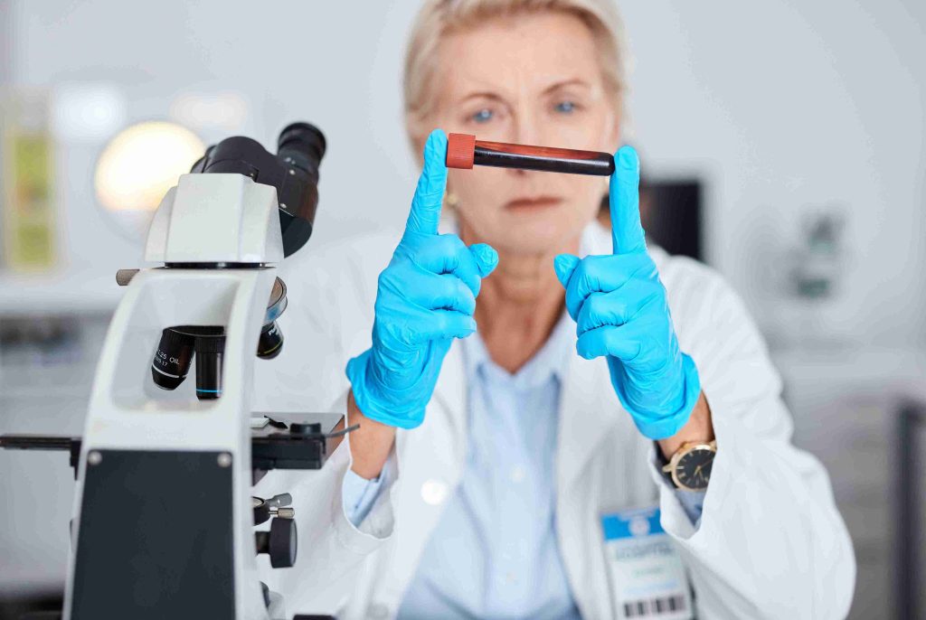 Healthcare worker holding a blood sample in the lab.