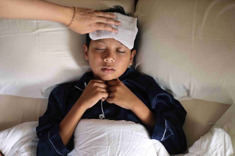 Child with fever sleeping in bed.